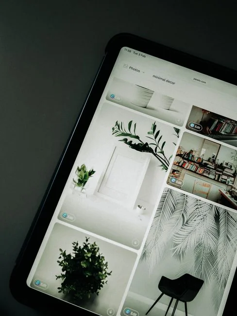Une personne utilise un ordinateur portable pour parcourir des sites de photos de stock. Travail en freelance dans un cadre chaleureux et confortable.